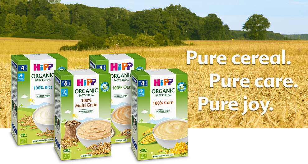 Four boxes of organic baby cereal are displayed against a backdrop of a wheat field, with the text "Pure cereal. Pure care. Pure joy." prominently featured.