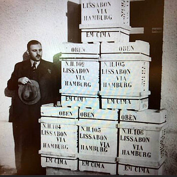 Georg Hipp Senior besides a tower of wooden export crates