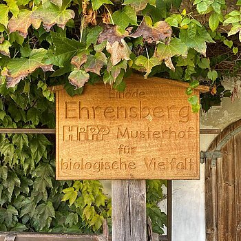 Wooden sign of the Ehrensberger Hof farm, HiPP's model farm for biodiversity